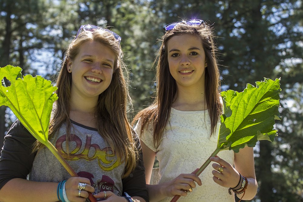 two teenage girls holding leaves