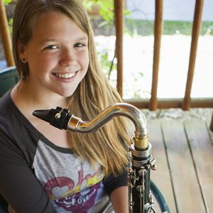 girl sitting on porch with saxophone
